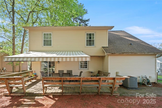 back of property featuring a wooden deck, a shingled roof, outdoor dining space, and cooling unit