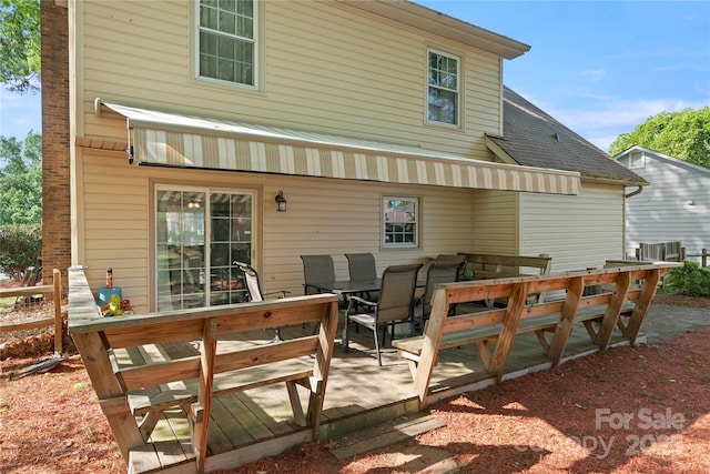 back of house featuring outdoor dining space and a wooden deck