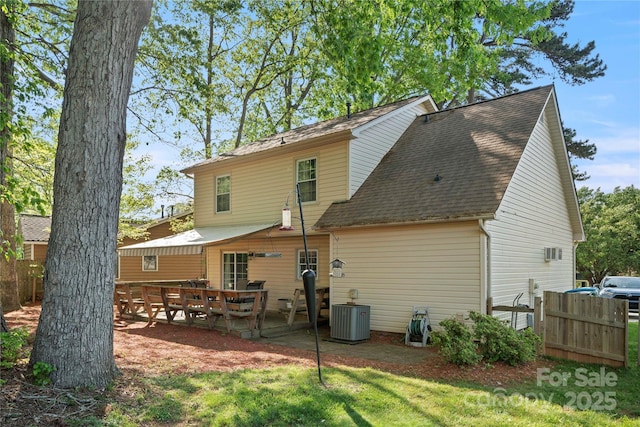 back of property featuring a patio, central AC, fence, and a shingled roof