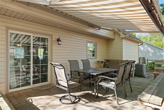 wooden deck featuring central AC unit and outdoor dining area