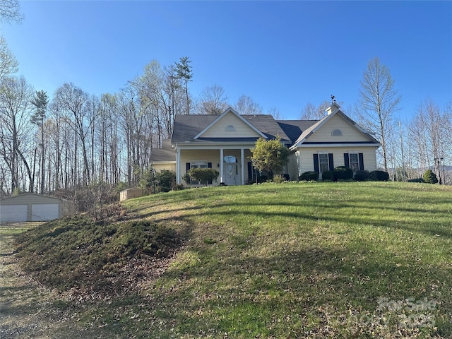 view of front facade with a detached garage and a front yard