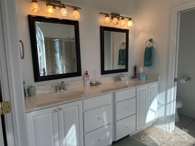 full bathroom featuring toilet, double vanity, a sink, and tile patterned flooring