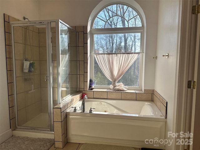 full bathroom featuring a shower stall, tile patterned floors, and a tub with jets