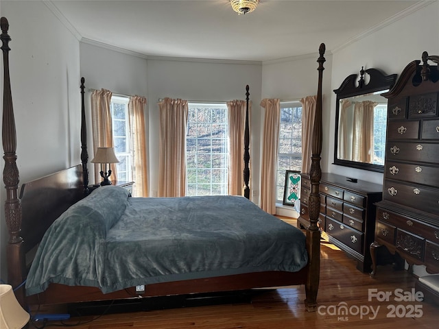 bedroom with crown molding and wood finished floors