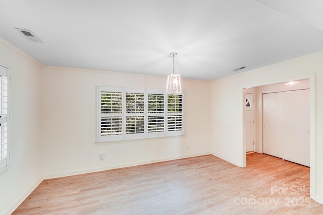 unfurnished dining area with crown molding, wood finished floors, baseboards, and visible vents