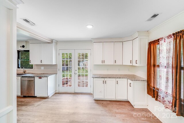 kitchen with light wood-style floors, french doors, stainless steel dishwasher, and visible vents