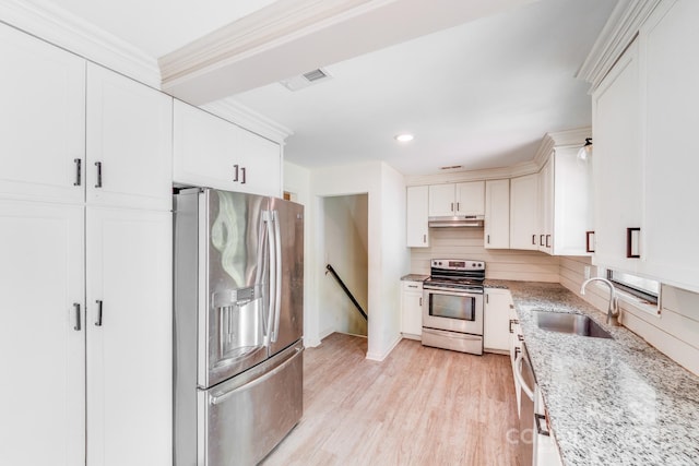 kitchen with light wood-type flooring, visible vents, under cabinet range hood, a sink, and stainless steel appliances