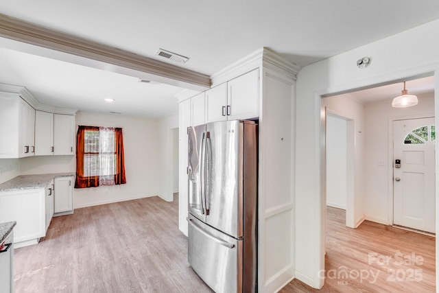kitchen featuring crown molding, white cabinetry, visible vents, stainless steel refrigerator with ice dispenser, and light wood finished floors