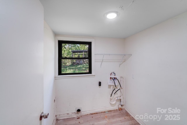 washroom featuring baseboards, wood finished floors, hookup for a washing machine, and laundry area