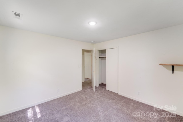 unfurnished bedroom featuring carpet, visible vents, and baseboards