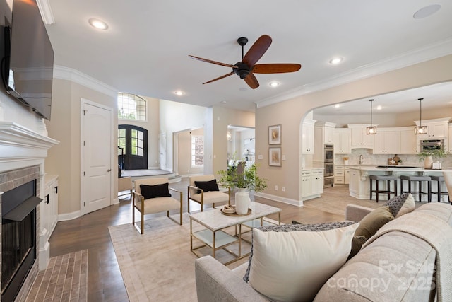 133 Crooked Branch Way, Troutman, NC 28166 - living area featuring a fireplace with flush hearth, crown molding, recessed lighting, wood finished floors, and a ceiling fan