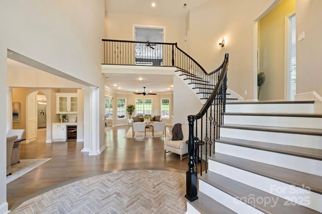 133 Crooked Branch Way, Troutman, NC 28166 - foyer featuring arched walkways, decorative columns, stairway, a ceiling fan, and wine cooler