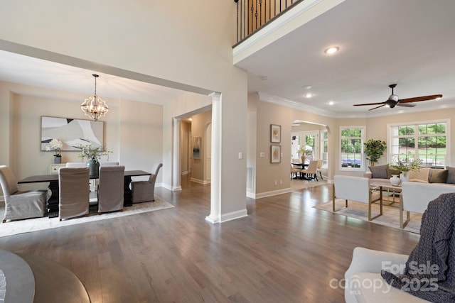 133 Crooked Branch Way, Troutman, NC 28166 - living room featuring arched walkways, wood finished floors, ceiling fan with notable chandelier, baseboards, and crown molding
