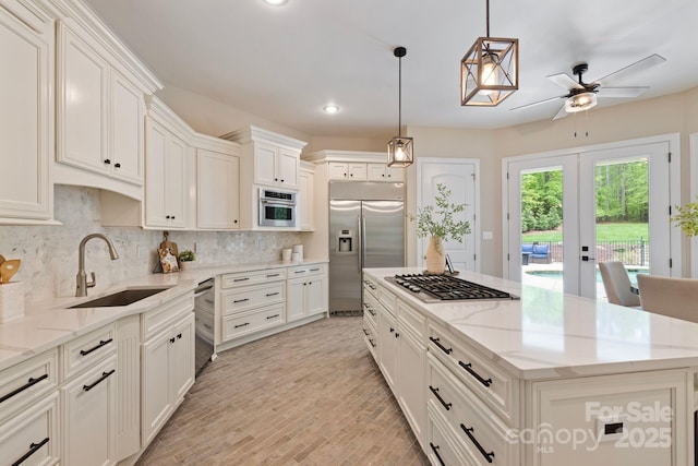 133 Crooked Branch Way, Troutman, NC 28166 - kitchen with a sink, stainless steel appliances, a ceiling fan, backsplash, and a kitchen island