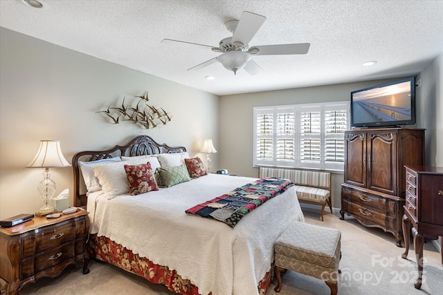 bedroom with radiator heating unit, light carpet, and a textured ceiling