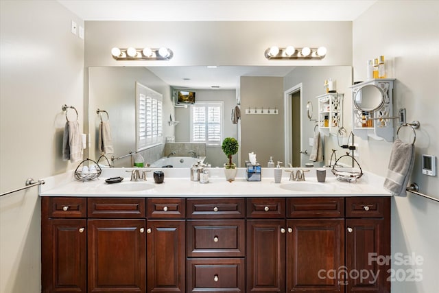 full bathroom featuring double vanity, a sink, and a garden tub