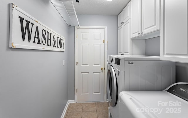 clothes washing area featuring independent washer and dryer, cabinet space, a textured ceiling, baseboards, and light tile patterned floors