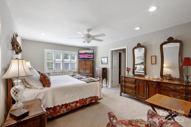bedroom featuring light carpet, a ceiling fan, recessed lighting, and a textured ceiling