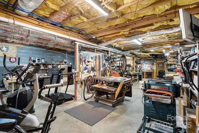 unfinished basement with concrete block wall and a workshop area