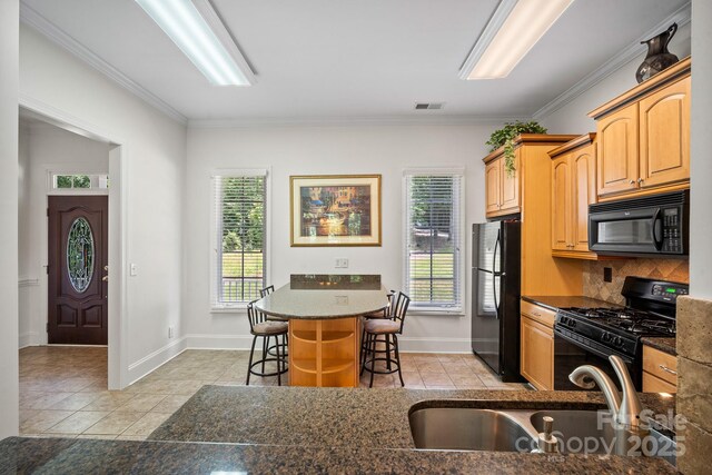 591 Emerald Isle Ct, Lexington, NC 27292 - kitchen featuring visible vents, a sink, a breakfast bar, black appliances, and light tile patterned flooring