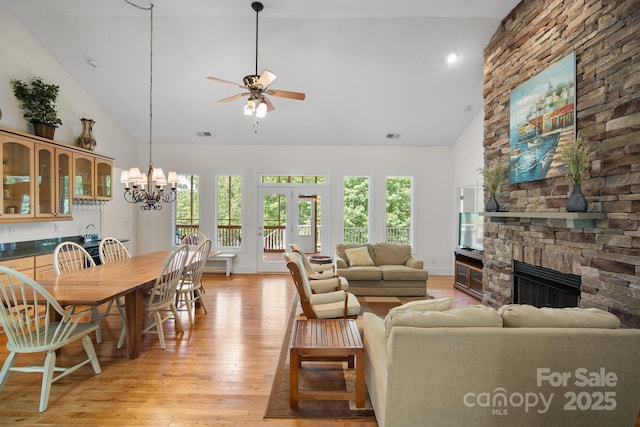 591 Emerald Isle Ct, Lexington, NC 27292 - living area with visible vents, light wood-type flooring, a fireplace, ceiling fan with notable chandelier, and high vaulted ceiling