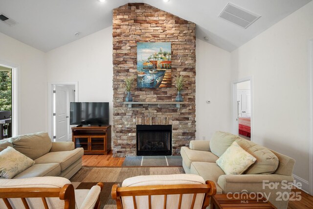 591 Emerald Isle Ct, Lexington, NC 27292 - living room featuring visible vents, a stone fireplace, and light wood finished floors