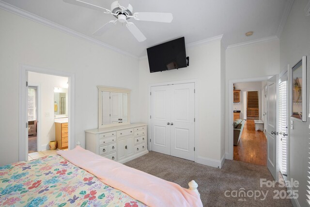 591 Emerald Isle Ct, Lexington, NC 27292 - bedroom with a closet, baseboards, ornamental molding, a ceiling fan, and light carpet