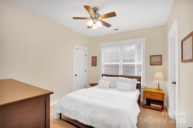 bedroom featuring visible vents, baseboards, ceiling fan, and light colored carpet