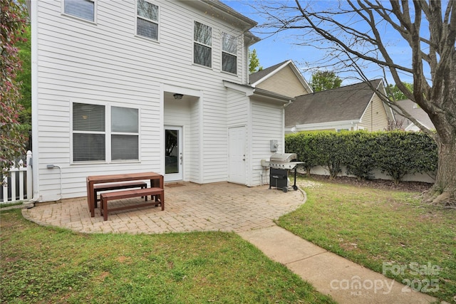 back of property with a yard, a patio area, and fence