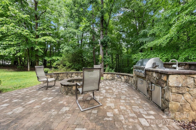 914 Elizabeth Ln, Matthews, NC 28105 - view of patio / terrace featuring area for grilling, an outdoor fire pit, exterior kitchen, view of wooded area, and a sink