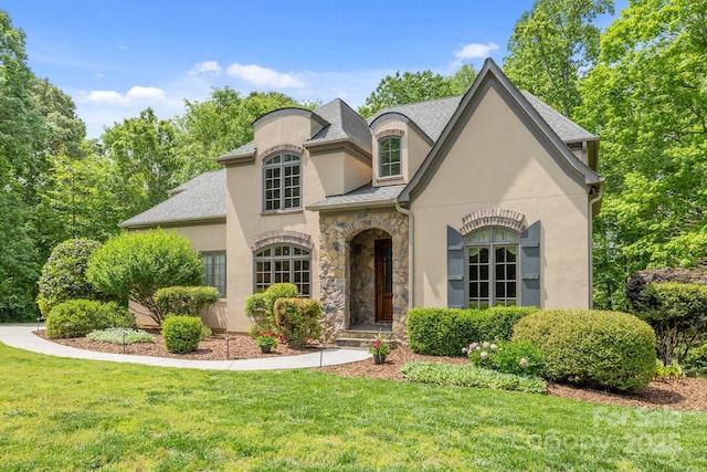 914 Elizabeth Ln, Matthews, NC 28105 - french provincial home with stucco siding, a front yard, stone siding, and roof with shingles