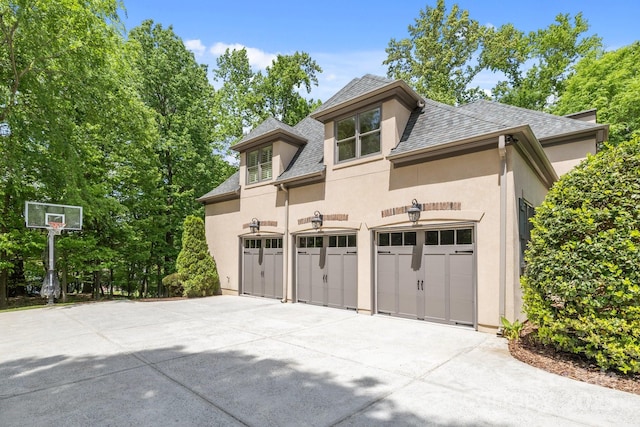 914 Elizabeth Ln, Matthews, NC 28105 - view of home's exterior featuring concrete driveway, stucco siding, a garage, and roof with shingles