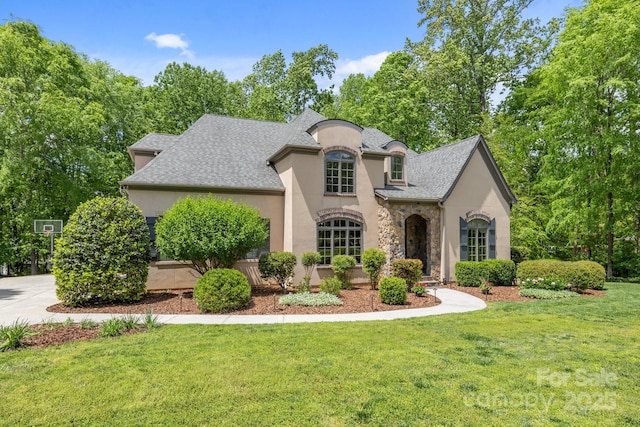 914 Elizabeth Ln, Matthews, NC 28105 - french provincial home featuring stucco siding, a front yard, stone siding, and roof with shingles