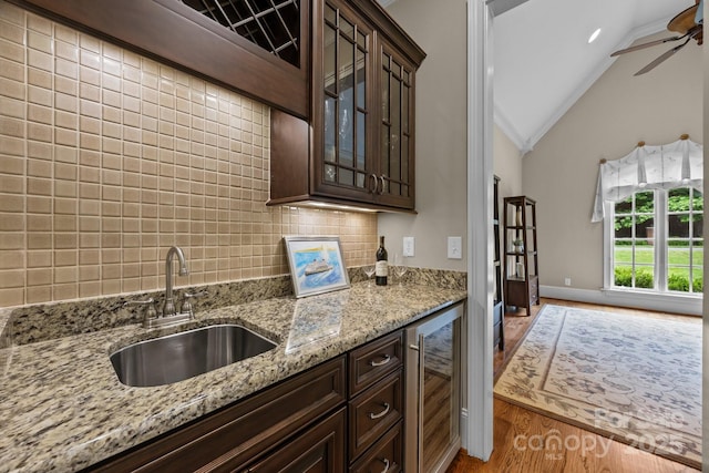 914 Elizabeth Ln, Matthews, NC 28105 - kitchen with beverage cooler, a sink, wood finished floors, dark brown cabinetry, and lofted ceiling