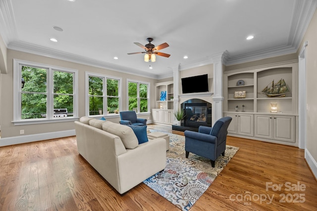914 Elizabeth Ln, Matthews, NC 28105 - living room featuring ceiling fan, a glass covered fireplace, baseboards, crown molding, and light wood finished floors