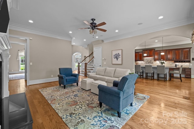 914 Elizabeth Ln, Matthews, NC 28105 - living room featuring arched walkways, a ceiling fan, recessed lighting, light wood-style floors, and crown molding