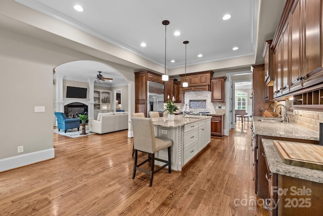 914 Elizabeth Ln, Matthews, NC 28105 - kitchen with stainless steel built in refrigerator, a sink, a ceiling fan, a fireplace, and a breakfast bar