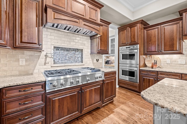 914 Elizabeth Ln, Matthews, NC 28105 - kitchen with appliances with stainless steel finishes, ornamental molding, backsplash, light wood-style flooring, and light stone counters