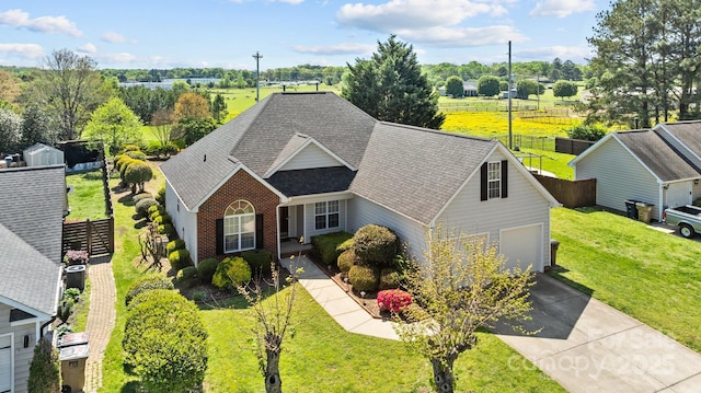 view of front of property featuring a garage, roof with shingles, fence, a front lawn, and driveway