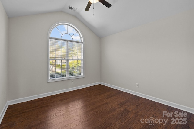 empty room featuring visible vents, baseboards, dark wood-style flooring, ceiling fan, and lofted ceiling