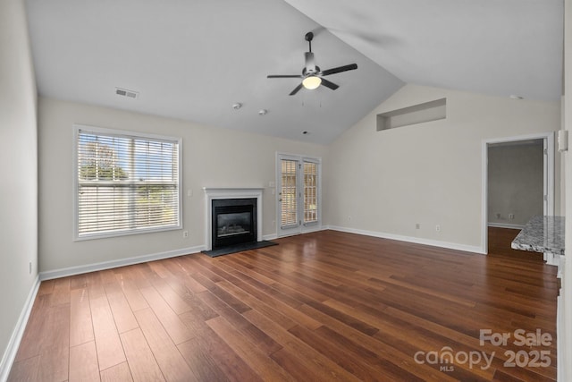 unfurnished living room featuring dark wood-style flooring, baseboards, a ceiling fan, visible vents, and high vaulted ceiling