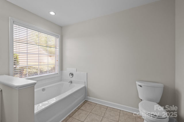 full bathroom with a wealth of natural light, tile patterned flooring, baseboards, and a garden tub