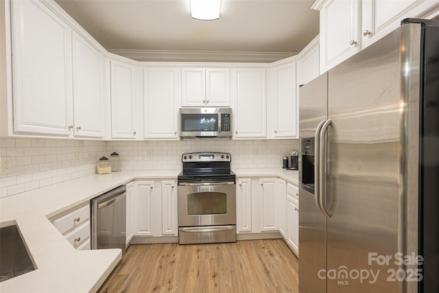 kitchen featuring appliances with stainless steel finishes, white cabinetry, and light countertops