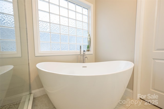 bathroom with plenty of natural light, tile patterned flooring, and baseboards