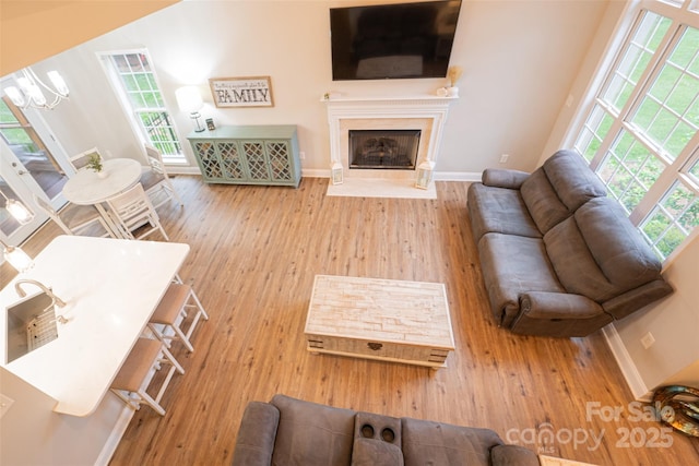 living area with baseboards, a healthy amount of sunlight, and wood finished floors