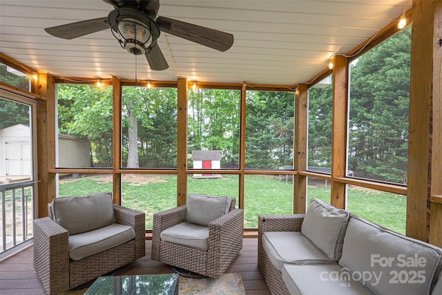 sunroom with a wealth of natural light, ceiling fan, and an outdoor living space