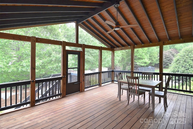 sunroom with a wealth of natural light, a ceiling fan, beam ceiling, and outdoor dining space