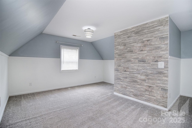 additional living space featuring lofted ceiling, visible vents, and carpet floors