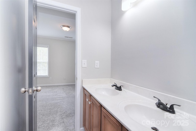 bathroom featuring baseboards, visible vents, a sink, and double vanity