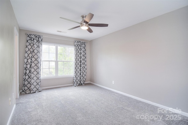 unfurnished room featuring carpet floors, visible vents, a ceiling fan, and baseboards